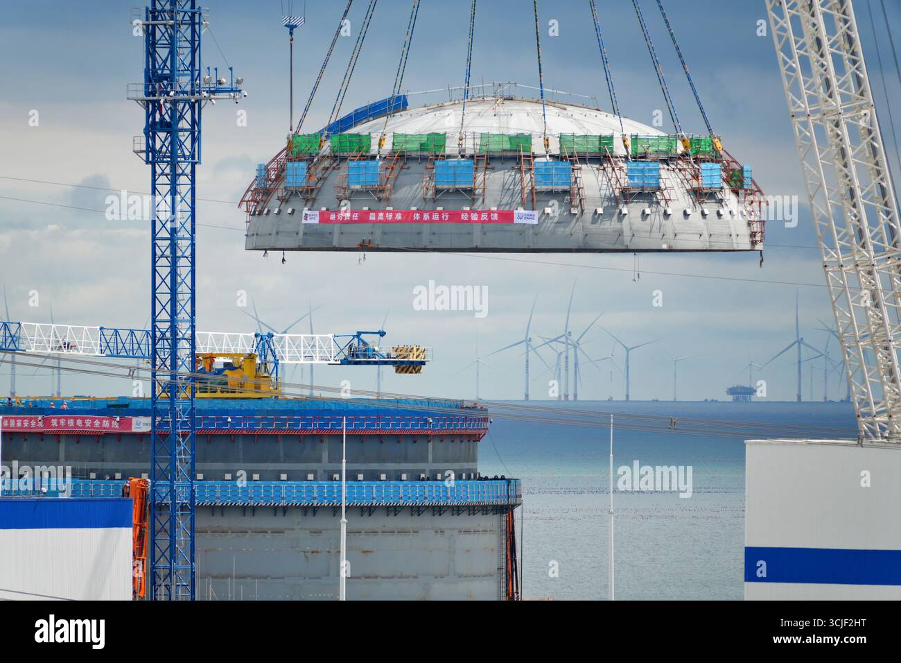 YANTAI, CHINE - 6 SEPTEMBRE 2025 - une grosse grue soulève la tête supérieure de la coque de sécurité de l'île nucléaire de l'unité 4 à la centrale nucléaire de Haiyang à Yantai, Shandong, Chine, le 6 septembre 2025. Banque D'Images