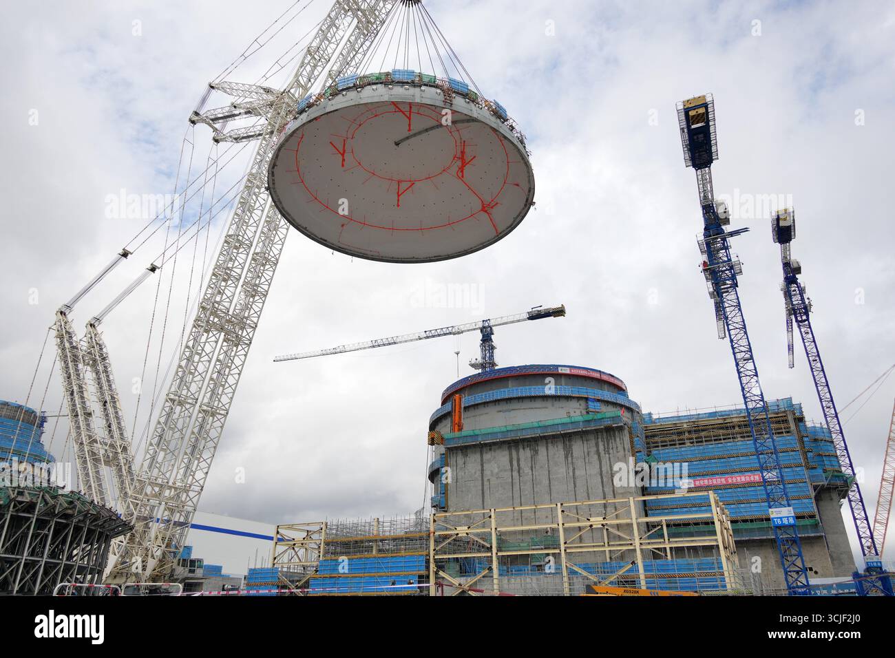 YANTAI, CHINE - 6 SEPTEMBRE 2025 - une grosse grue soulève la tête supérieure de la coque de sécurité de l'île nucléaire de l'unité 4 à la centrale nucléaire de Haiyang à Yantai, Shandong, Chine, le 6 septembre 2025. Banque D'Images