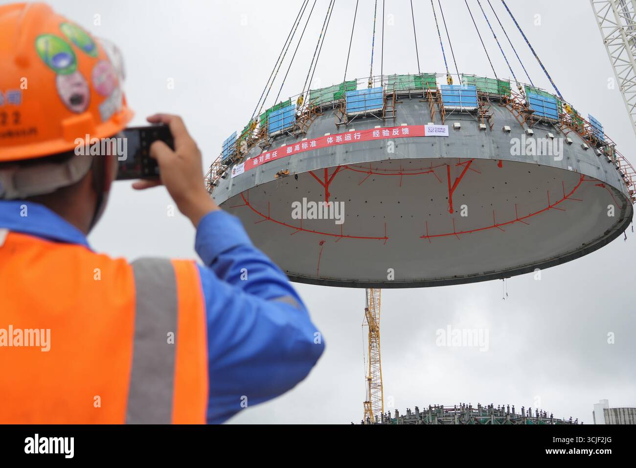 YANTAI, CHINE - 6 SEPTEMBRE 2025 - le personnel surveille le levage de la tête supérieure du navire de confinement nucléaire de l'île pour l'unité 4 à la centrale nucléaire de Haiyang à Yantai, Shandong, Chine, le 6 septembre 2025. Banque D'Images