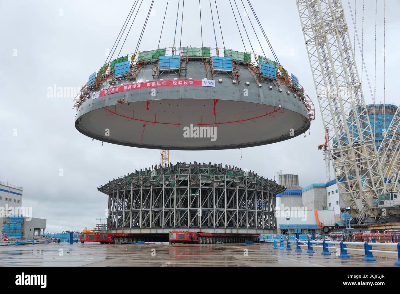 YANTAI, CHINE - 6 SEPTEMBRE 2025 - une grosse grue soulève la tête supérieure de la coque de sécurité de l'île nucléaire de l'unité 4 à la centrale nucléaire de Haiyang à Yantai, Shandong, Chine, le 6 septembre 2025. Banque D'Images