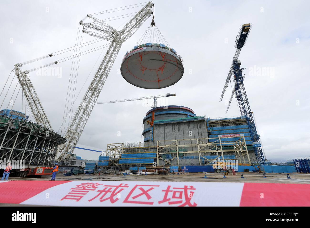 YANTAI, CHINE - 6 SEPTEMBRE 2025 - une grosse grue soulève la tête supérieure de la coque de sécurité de l'île nucléaire de l'unité 4 à la centrale nucléaire de Haiyang à Yantai, Shandong, Chine, le 6 septembre 2025. Banque D'Images