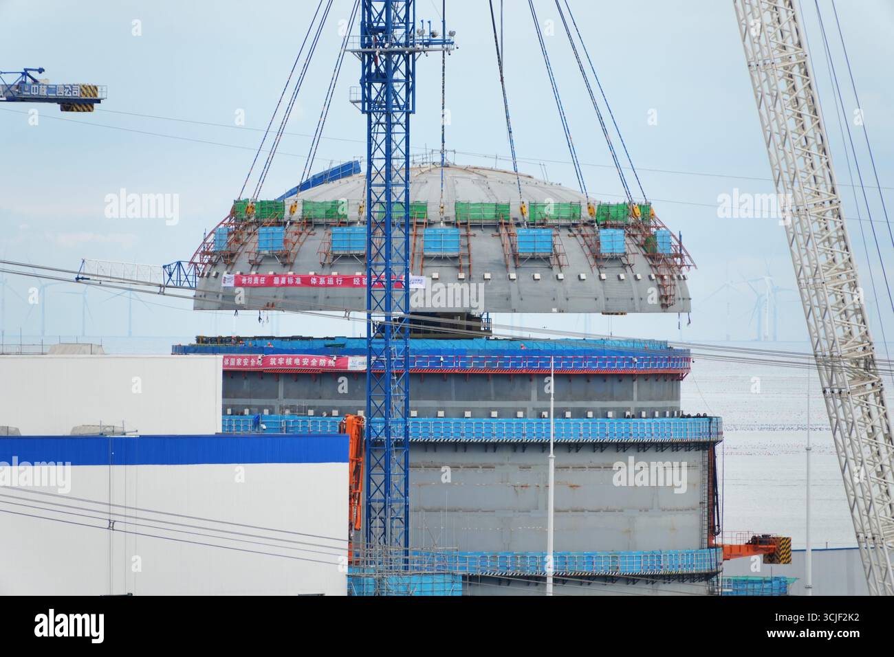 YANTAI, CHINE - 6 SEPTEMBRE 2025 - une grosse grue soulève la tête supérieure de la coque de sécurité de l'île nucléaire de l'unité 4 à la centrale nucléaire de Haiyang à Yantai, Shandong, Chine, le 6 septembre 2025. Banque D'Images