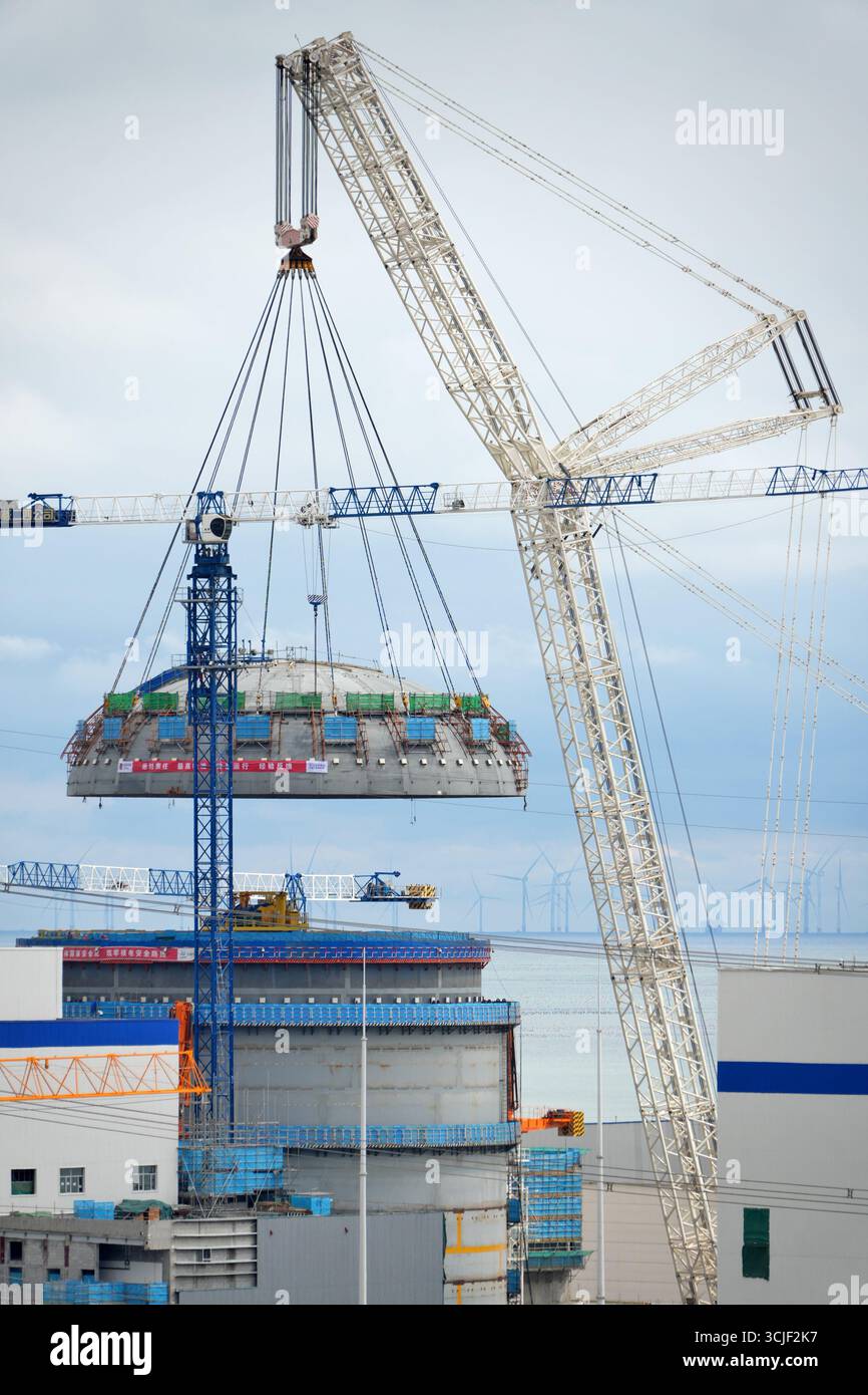 YANTAI, CHINE - 6 SEPTEMBRE 2025 - une grosse grue soulève la tête supérieure de la coque de sécurité de l'île nucléaire de l'unité 4 à la centrale nucléaire de Haiyang à Yantai, Shandong, Chine, le 6 septembre 2025. Banque D'Images