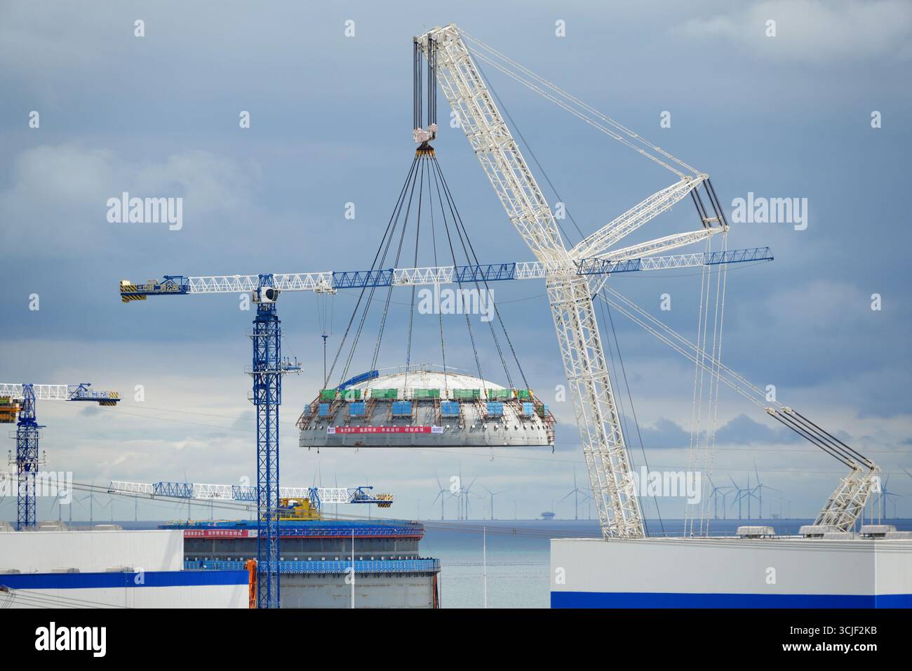 YANTAI, CHINE - 6 SEPTEMBRE 2025 - une grosse grue soulève la tête supérieure de la coque de sécurité de l'île nucléaire de l'unité 4 à la centrale nucléaire de Haiyang à Yantai, Shandong, Chine, le 6 septembre 2025. Banque D'Images