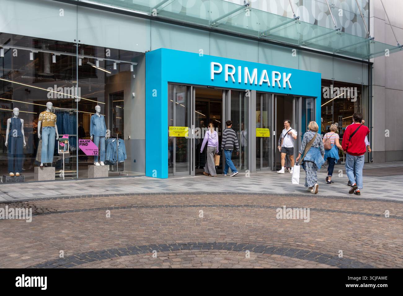 Sept 2025 acheteurs de vêtements avec des sacs entrant et sortant d'un magasin de vêtements Primark à Newbury, Berkshire, Angleterre, Royaume-Uni Banque D'Images