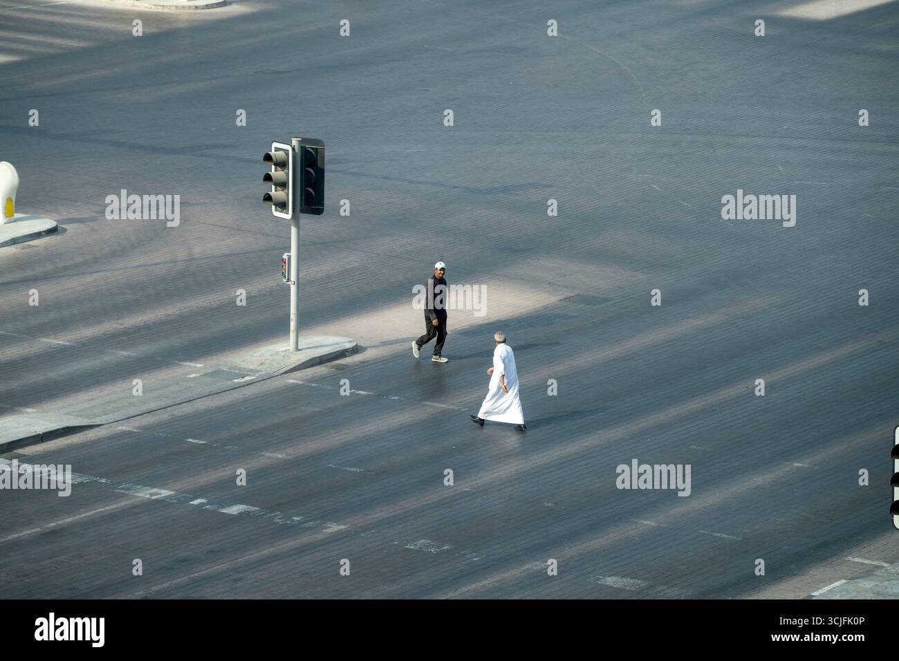 Doha, Qatar - 30 août 2025 : vue aérienne des hommes arabes sur le passage piétonnier sur la route Banque D'Images