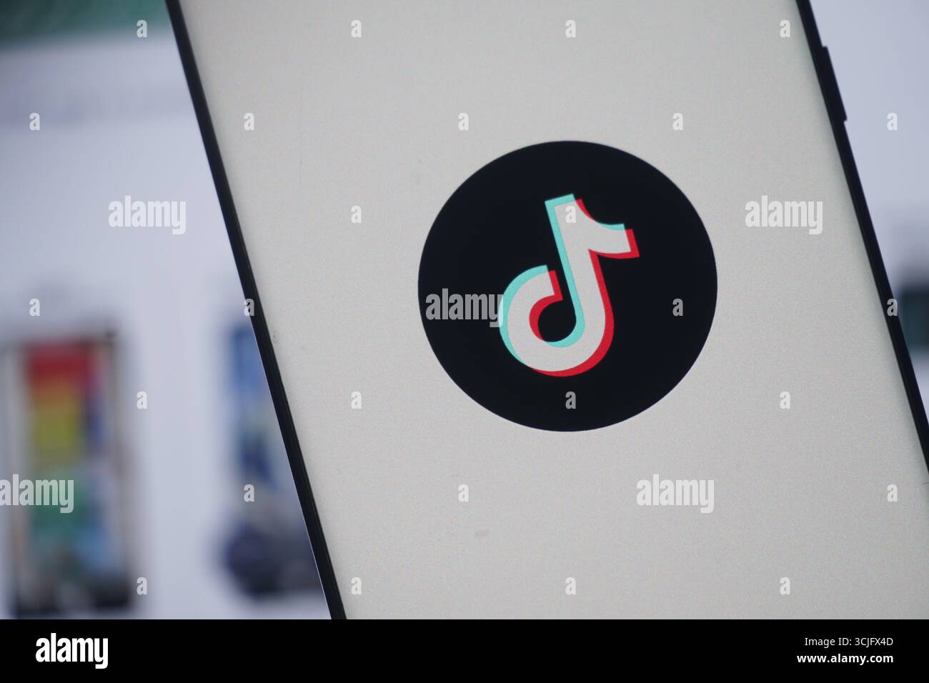 Écran de smartphone affichant le logo TikTok, cercle noir sur fond blanc Banque D'Images