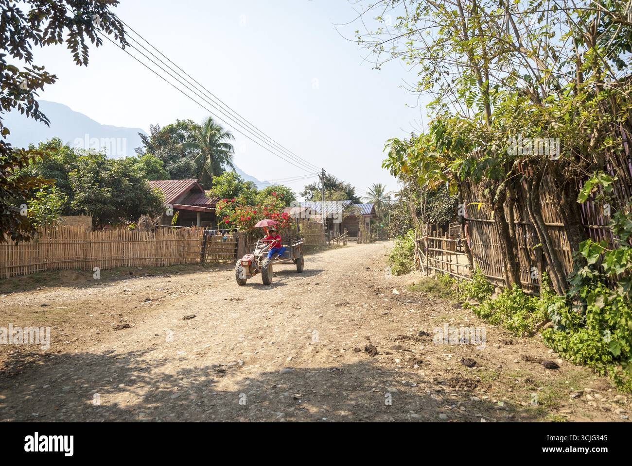 Vang Vieng, Laos - Feb 2016 : l'homme de la conduite du tracteur à travers le village près de Vang Vieng, Laos Banque D'Images
