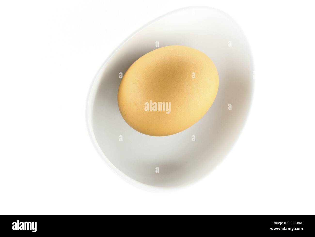 Oeuf brun biologique dans un bol sur fond blanc Banque D'Images