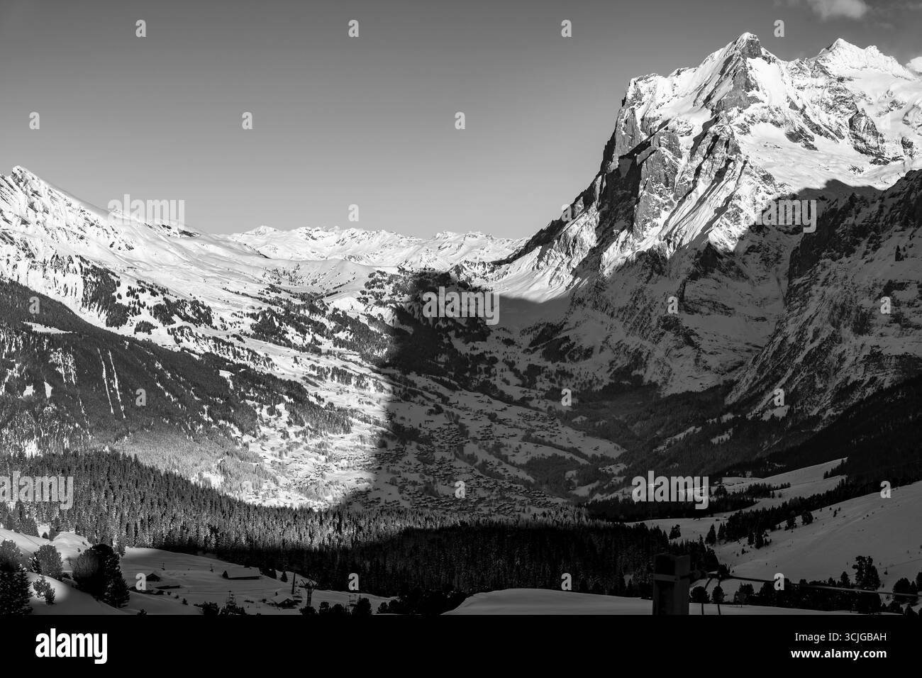 Belle vue panoramique sur la chaîne de montagnes enneigée et le pic Wetterhorn 3692 mètres de haut et village dans la vallée dans les Alpes suisses dans un hiver ensoleillé Banque D'Images