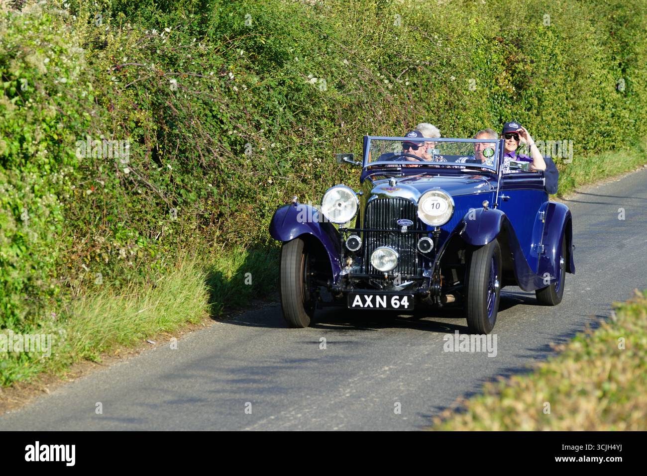 Voiture d'époque explorant les routes rurales avec des conducteurs appréciant une route panoramique. Shere Hill Climb, East Clandon, Guildford Banque D'Images