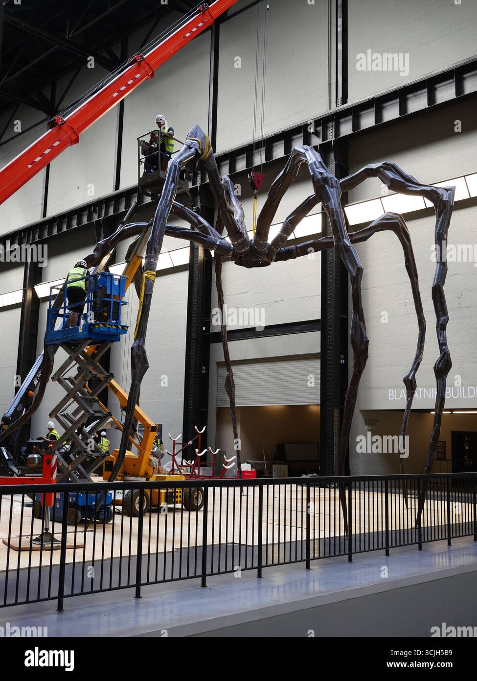 Le personnel de la Tate Modern Work Moving Maman, la sculpture d'araignée de l'artiste Louise Bourgeois. Galerie d'art contemporain Tate Modern, Londres, Royaume-Uni Banque D'Images