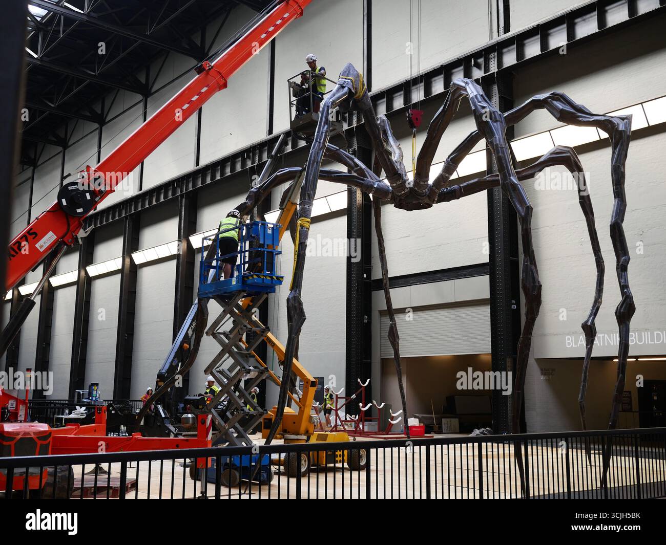 Le personnel de la Tate Modern Work Moving Maman, la sculpture d'araignée de l'artiste Louise Bourgeois. Galerie d'art contemporain Tate Modern, Londres, Royaume-Uni Banque D'Images