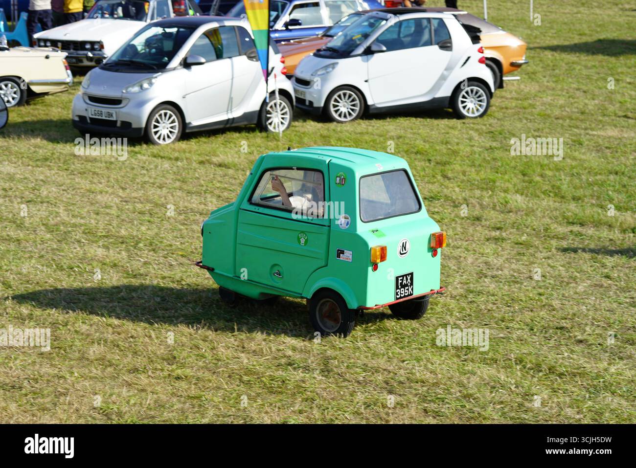 Green Microcar conduisant au Vintage Auto Show avec d'autres voitures classiques. Shere Hill Climb, East Clandon, Guildford Banque D'Images