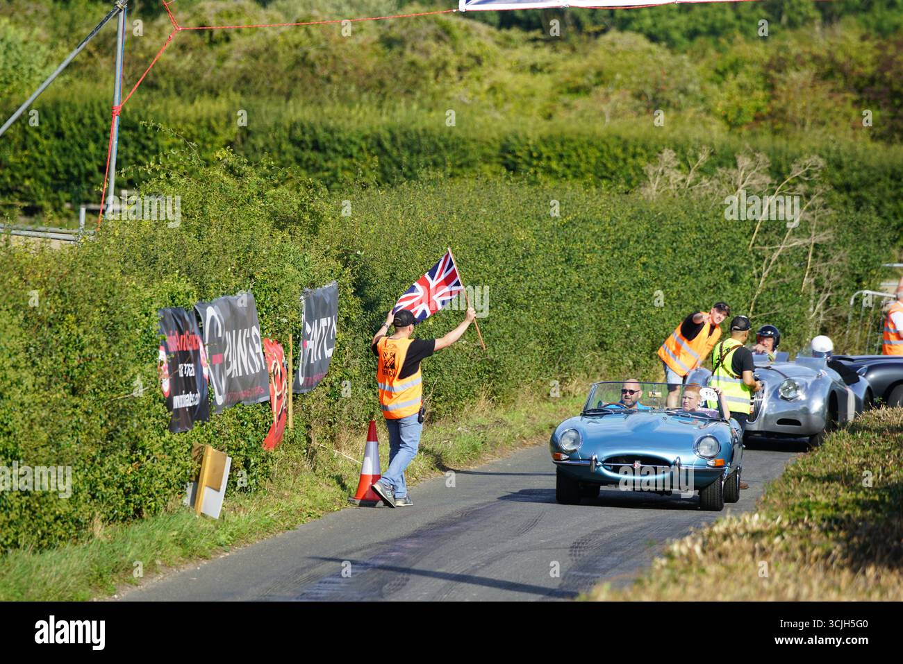 Rallye de voitures classiques avec drapeau britannique sur la route panoramique. Shere Hill Climb, East Clandon, Guildford Banque D'Images