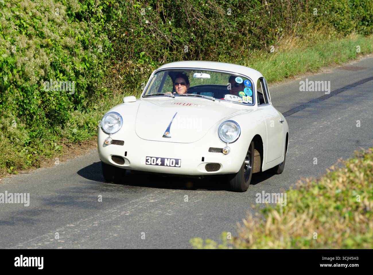 Classic White Vintage car conduisant à travers Countryside Road avec de la verdure. Shere Hill Climb, East Clandon, Guildford Banque D'Images