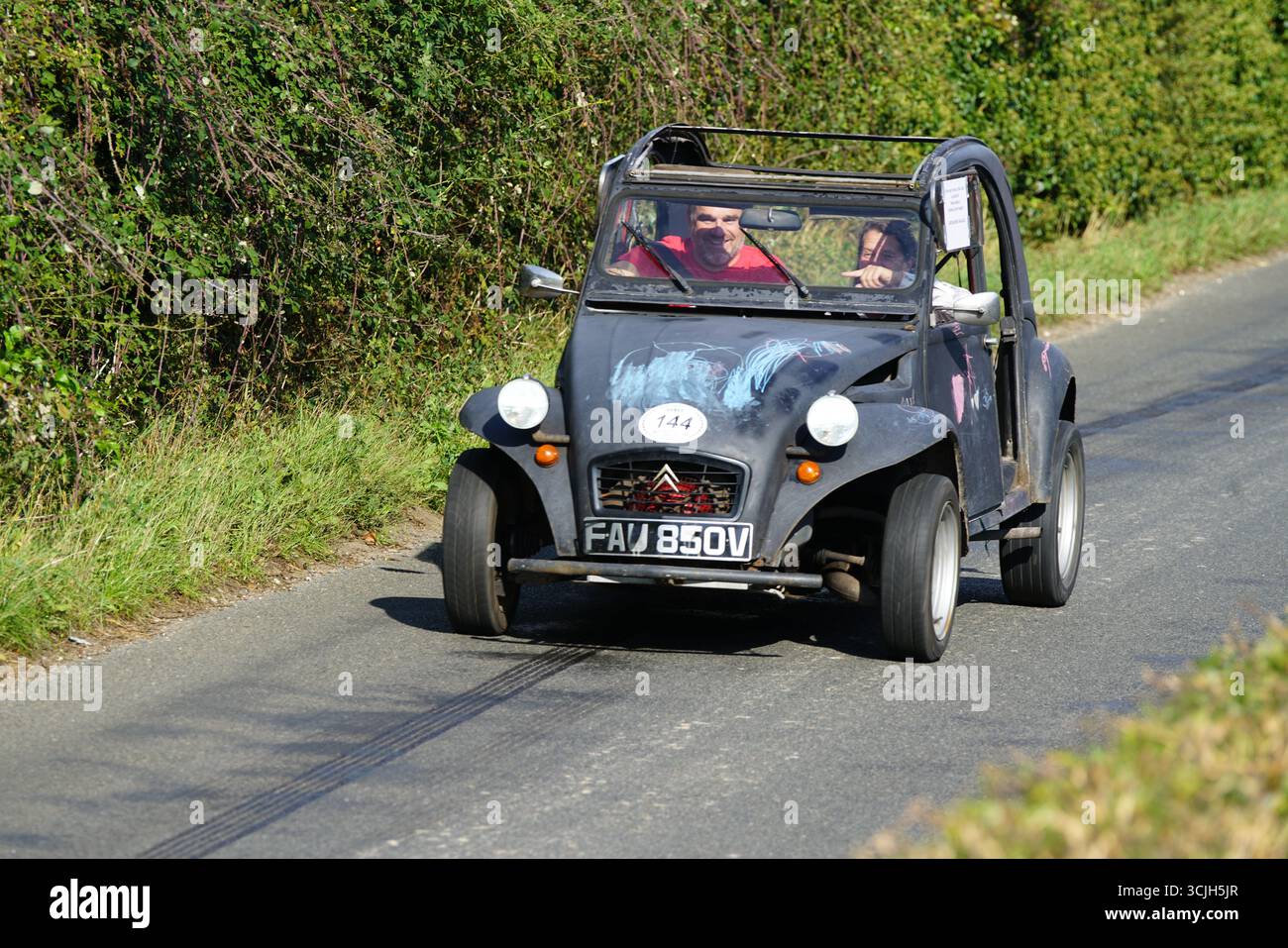 Voiture classique conduisant sur une route de campagne panoramique. Shere Hill Climb, East Clandon, Guildford Banque D'Images