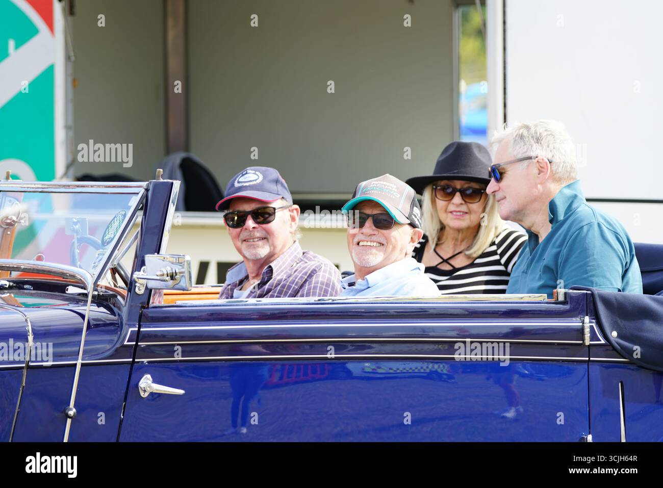 Groupe d'amis profitant d'un tour de voiture cabriolet classique à l'extérieur. Shere Hill Climb, East Clandon, Guildford Banque D'Images