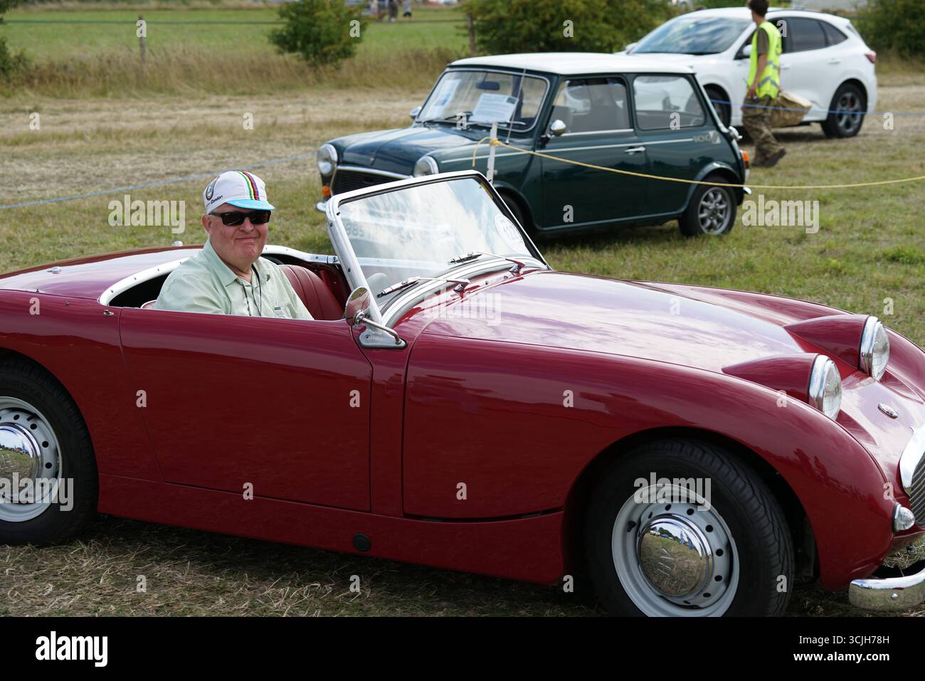 Passionné de voitures anciennes appréciant un cabriolet vintage lors d'un événement en plein air. Shere Hill Climb, East Clandon, Guildford Banque D'Images