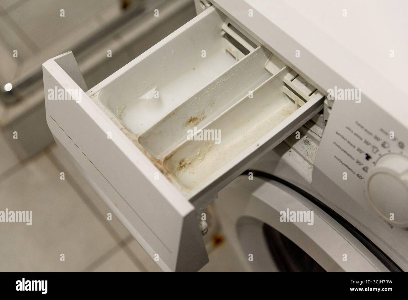Retirez le plateau sale tiroir de lave-linge recouvert de vieux détergent à lessive et de calcaire dû à l'eau solide Banque D'Images Retirez le plateau sale tiroir de lave-linge recouvert de vieux détergent à lessive et de calcaire dû à l'eau solide Banque D'Images