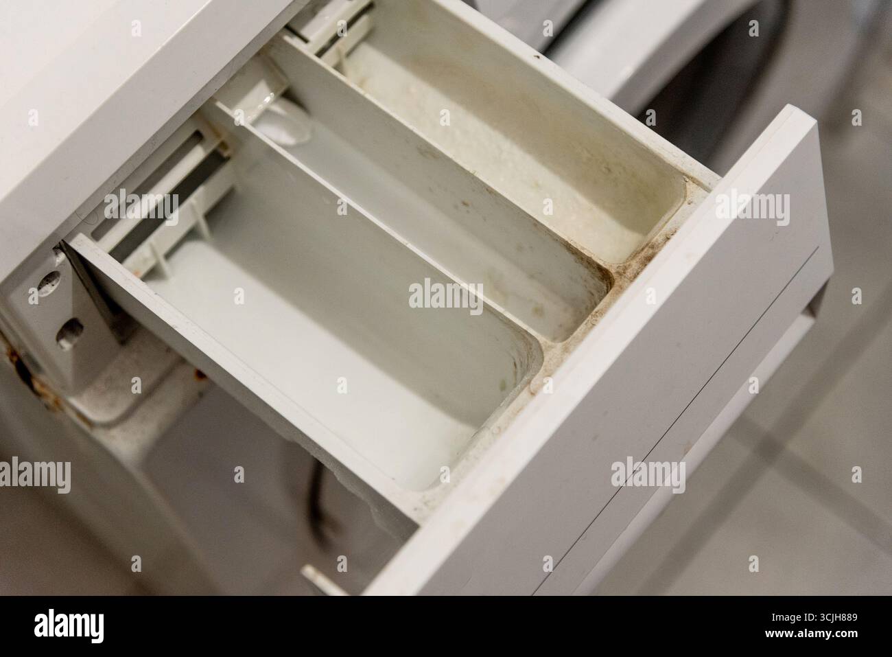 Retirez le plateau sale tiroir de lave-linge recouvert de vieux détergent à lessive et de calcaire dû à l'eau solide Banque D'Images Retirez le plateau sale tiroir de lave-linge recouvert de vieux détergent à lessive et de calcaire dû à l'eau solide Banque D'Images