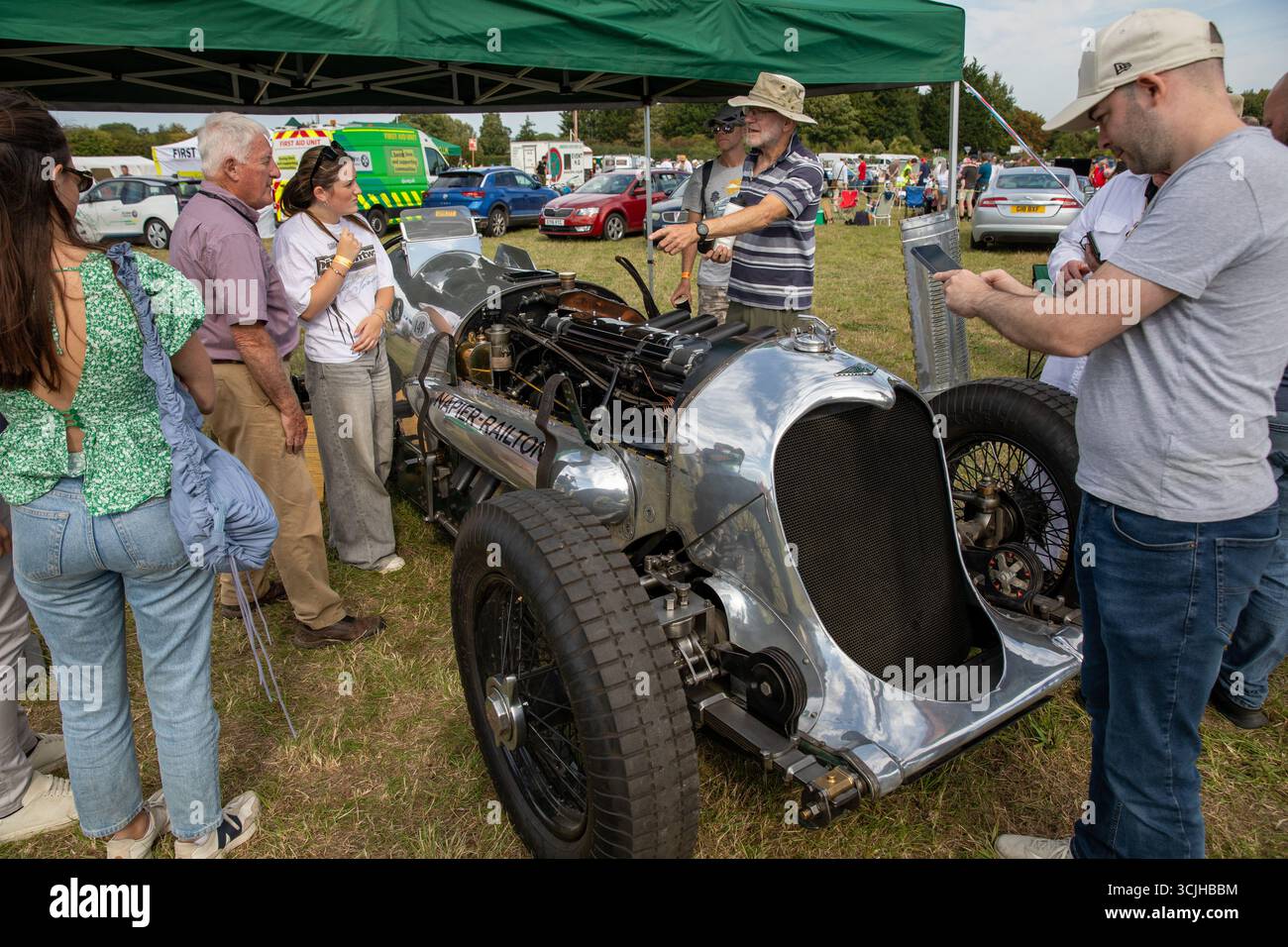 Guilford, Royaume-Uni. 07 septembre 2025. Les membres du public se rassemblent autour d'une voiture de course Napier-Railton de 24 litres. La 13e ascension de Shere Hill a attiré des centaines de passionnés d'automobile. Cet événement automobile annuel met en vedette des participants du public conduisant des véhicules standard, ainsi que des propriétaires de voitures de course, classiques et supercars, qui concourent sur une voie publique fermée pour obtenir le meilleur temps contre la montre. Outre la montée de la colline, les concurrents et les spectateurs ont eu la chance de voir les voitures concurrentes dans la grande zone de paddock à la ligne de départ du parcours. Crédit : SOPA images Limited/Alamy Live News Banque D'Images