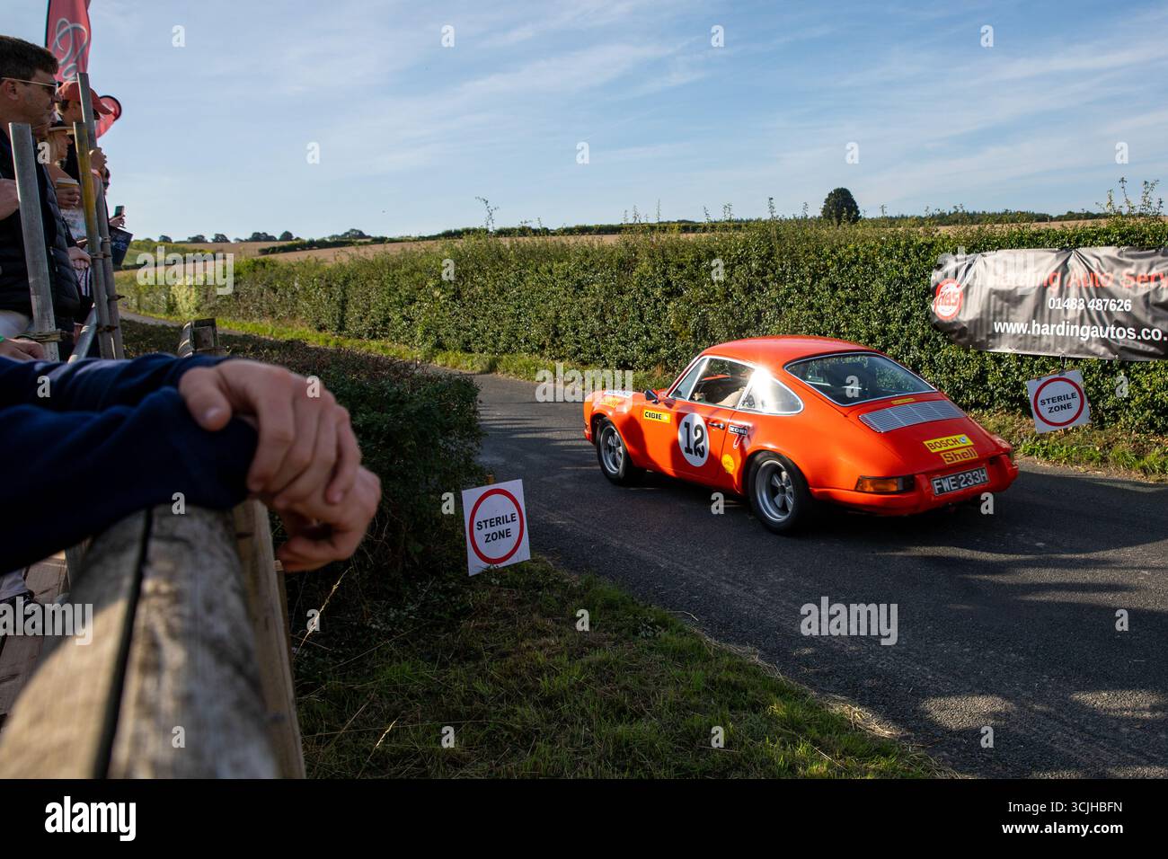 Guilford, Royaume-Uni. 07 septembre 2025. Une Porsche 911 commence une montée en côte devant les spectateurs. La 13e ascension de Shere Hill a attiré des centaines de passionnés d'automobile. Cet événement automobile annuel met en vedette des participants du public conduisant des véhicules standard, ainsi que des propriétaires de voitures de course, classiques et supercars, qui concourent sur une voie publique fermée pour obtenir le meilleur temps contre la montre. Outre la montée de la colline, les concurrents et les spectateurs ont eu la chance de voir les voitures concurrentes dans la grande zone de paddock à la ligne de départ du parcours. Crédit : SOPA images Limited/Alamy Live News Banque D'Images