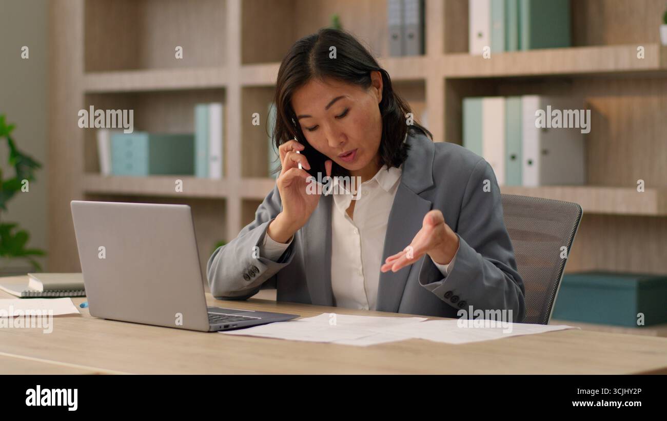 Femme asiatique femme vendeuse employeur avocat chinois coréen japonaise jeune femme d'affaires multitâche travailleur parler téléphone portable appeler téléphone portable téléphone mobile Banque D'Images