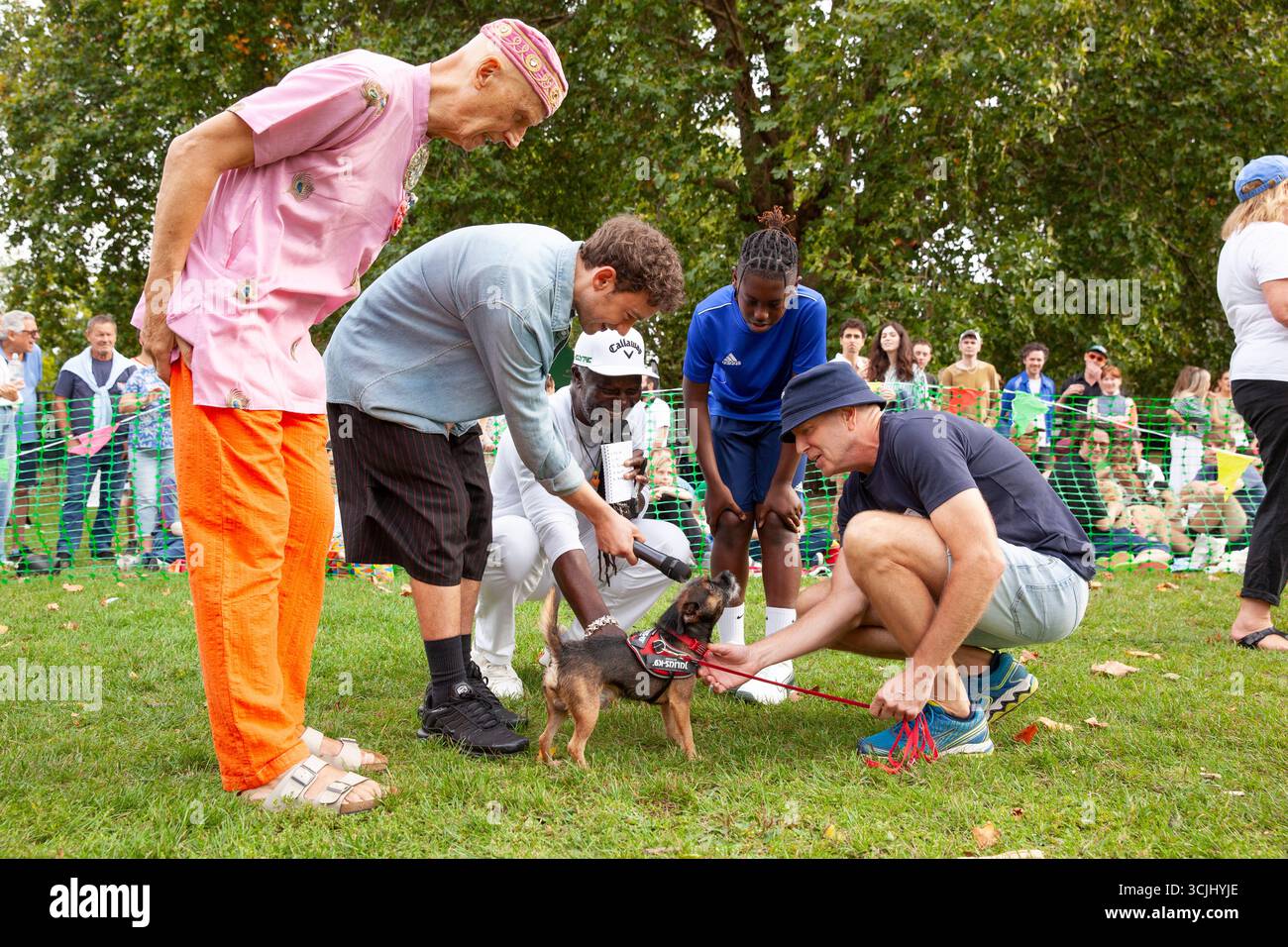 Londres, Royaume-Uni. 7 septembre 2025. Le chanteur et acteur Olly Alexander, le chef et entrepreneur Levi Roots (avec son fils Christopher), et l'artiste Andrew Logan étaient les juges cette année pour le Myatt's Fields Dog Show. Se déroulant dans un parc près de Brixton, le spectacle comprend des récompenses pour Perfect Puppy, Golden Oldie, Remarkable Rescue, Agility, Doggy doppelganger et un concours de costumes pour la Journée mondiale du livre. Ici Olly tient le micro pour un chien qui sait chanter. Crédit : Anna Watson/Alamy Live News Banque D'Images