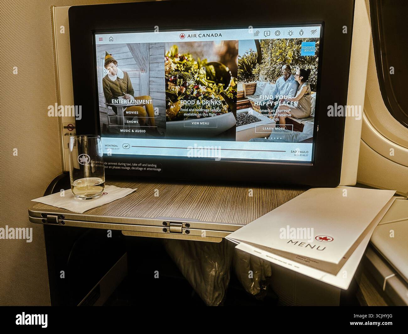 Buenos Aires, Argentine – le 19 décembre 2022 : vue de l'écran de divertissement de classe signature d'Air Canada et de la table de plateau pendant les vols long-courriers internationaux Banque D'Images Buenos Aires, Argentine – le 19 décembre 2022 : vue de l'écran de divertissement de classe signature d'Air Canada et de la table de plateau pendant les vols long-courriers internationaux Banque D'Images