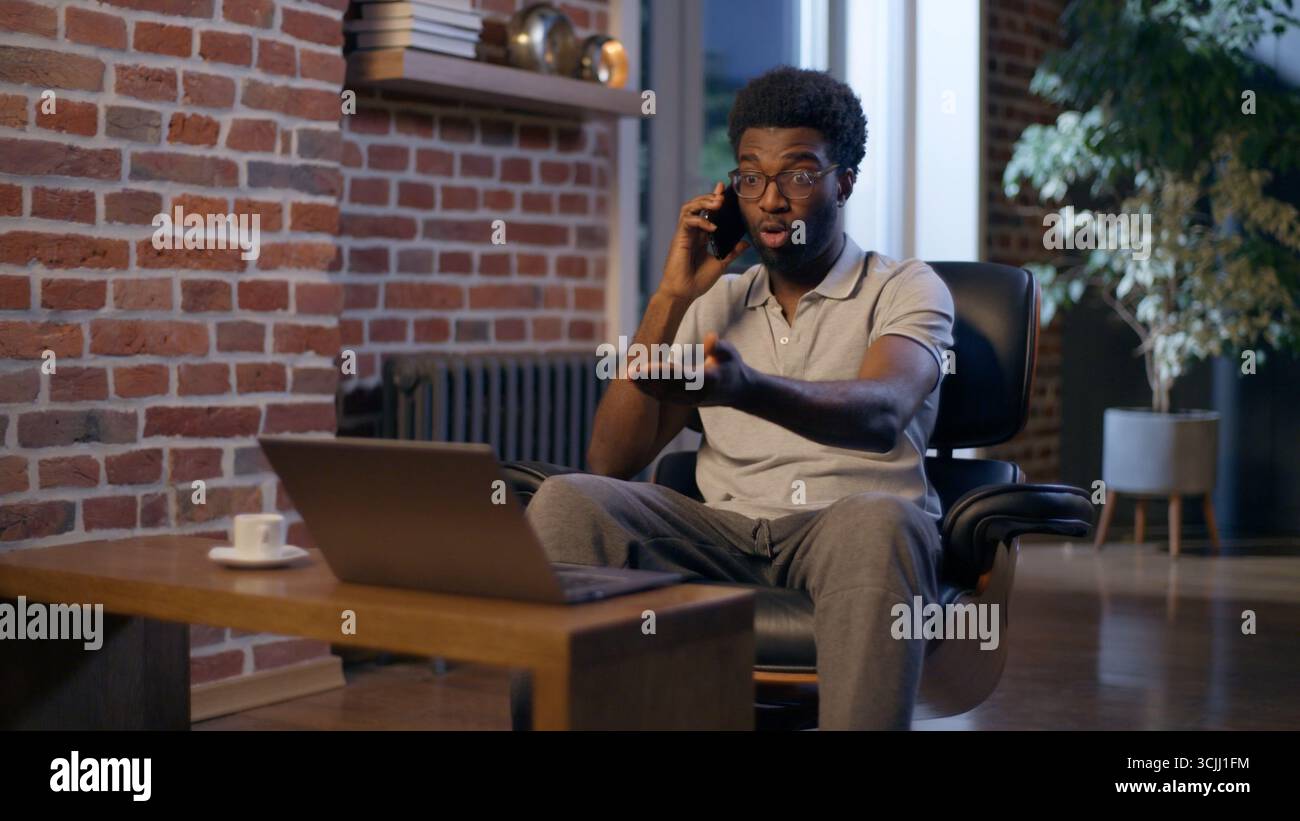 Homme d'affaires afro-américain appeler entrepreneur de téléphone mobile homme d'affaires heures supplémentaires dans le bureau de nuit souriant Guy employeur parler smartphone homme amical Banque D'Images