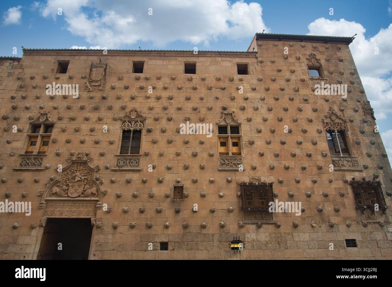 Façade avec des coquillages à Casa de las Conchas : mur de grès historique avec des coquilles Saint-Jacques et grille de fenêtre ornée dans la célèbre Casa de las Conc de Salamanque Banque D'Images