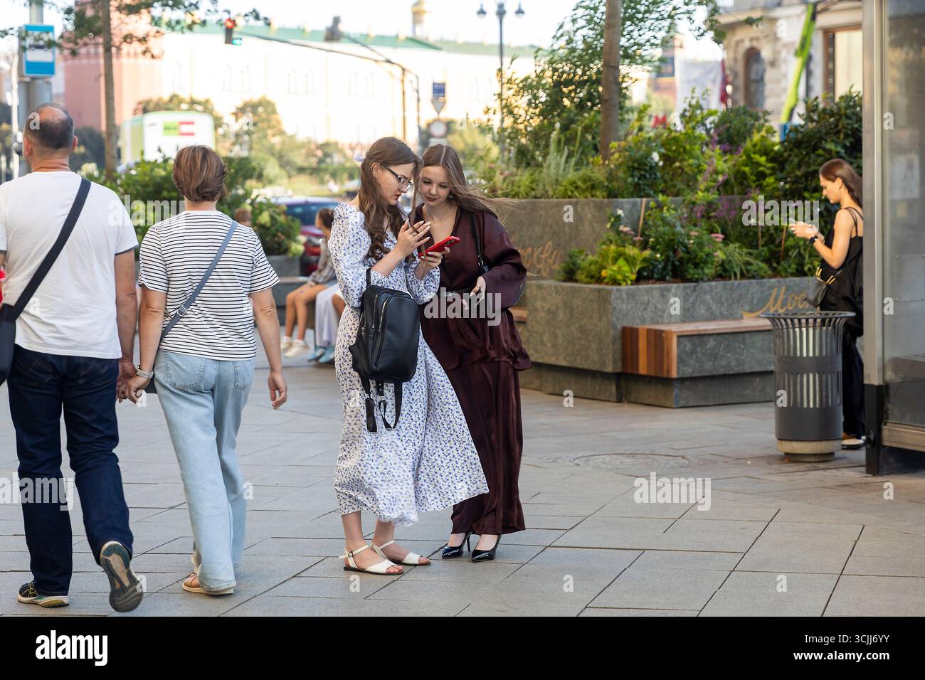 Moscou, Russie, 25 août 2025, jeunes femmes regardant leur téléphone dans une rue de Moscou. Banque D'Images