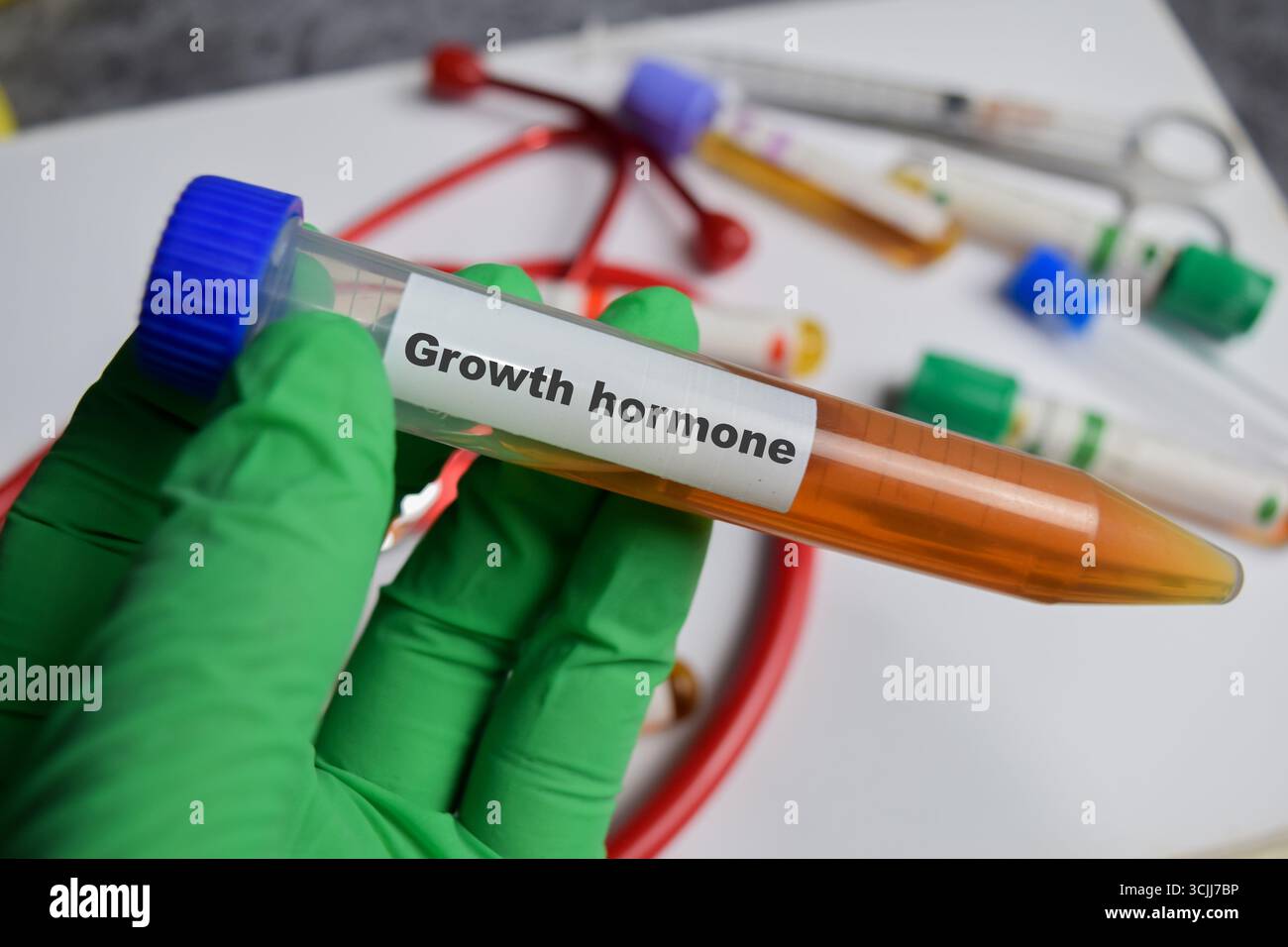 Médicament vaccinal à l'hormone de croissance dans les mains vertes gantées. Concept médical Banque D'Images
