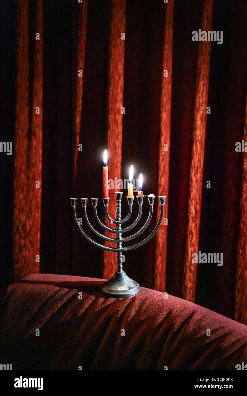 Une menorah Hanukah argentée avec des bougies allumées - un bougeoir juif à neuf bras / chandelier utilisé pour célébrer la fête juive de Hanukah Banque D'Images