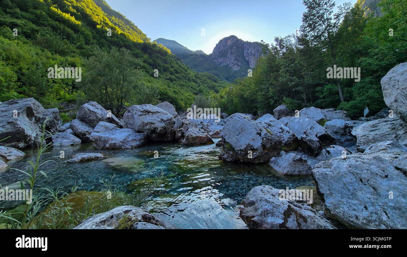 Ruisseau avec des pierres au premier plan le long du sentier Blue Eye près de Theth, avec les Alpes albanaises en arrière-plan, Albanie. Banque D'Images