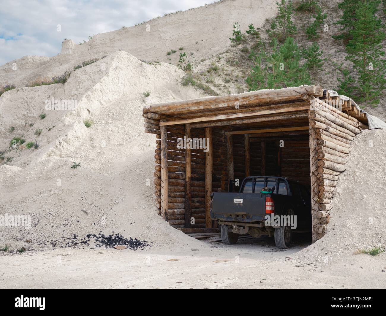 Vue arrière d'une camionnette militaire garée à l'intérieur d'une rigole en bois ou d'un abri dans une carrière. Le véhicule est camouflé, prêt pour une mission. Banque D'Images