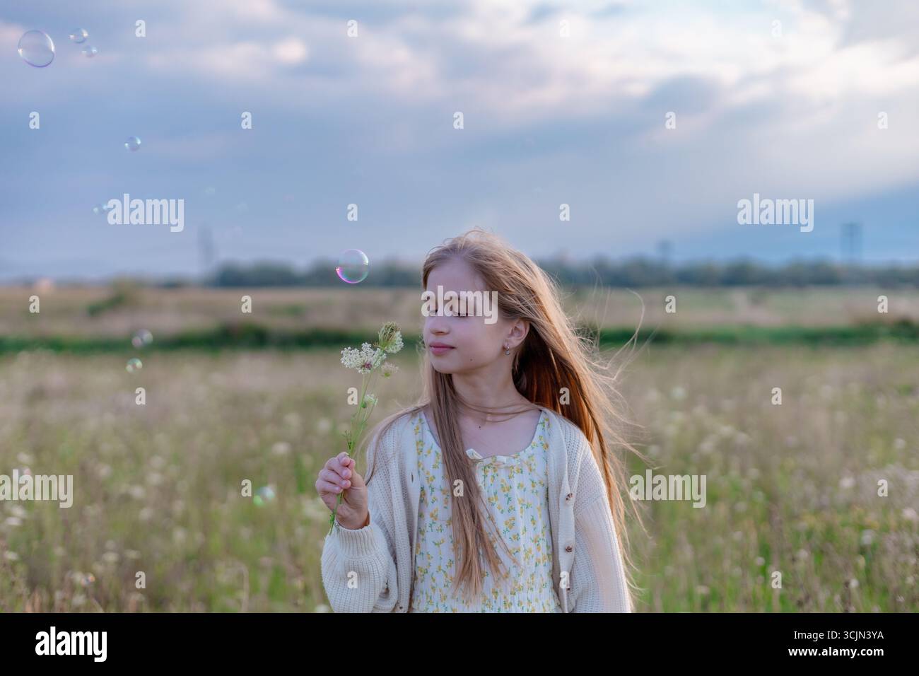 Les filles sur le terrain d'été et les bulles de savon Banque D'Images