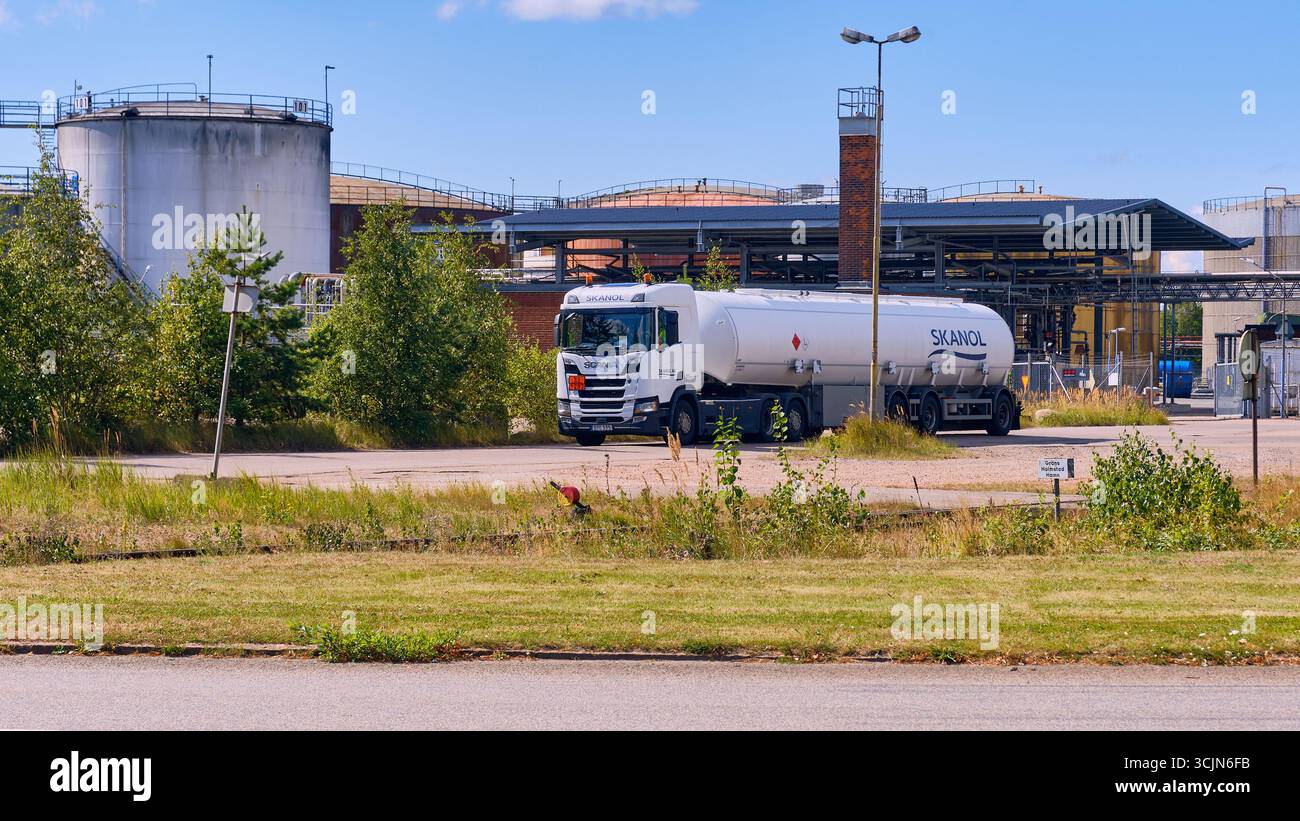 Halmstad, Suède ; 25 août 2023 : camion-citerne Skanol quittant l'installation de stockage de pétrole avec de grands réservoirs visibles en arrière-plan. Banque D'Images