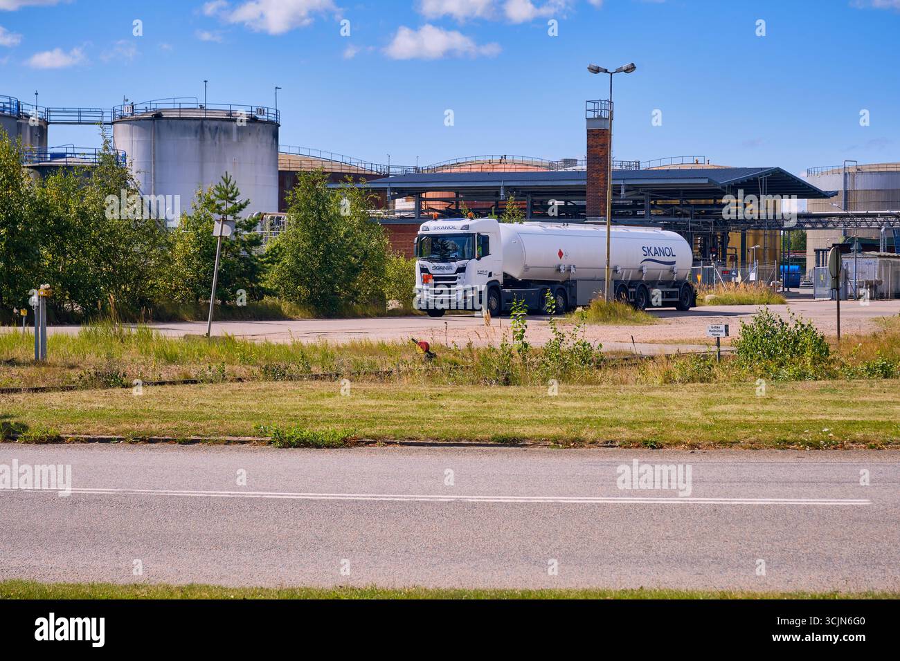 Halmstad, Suède ; 25 août 2023 : camion-citerne Skanol quittant l'installation de stockage de pétrole avec de grands réservoirs visibles en arrière-plan. Banque D'Images