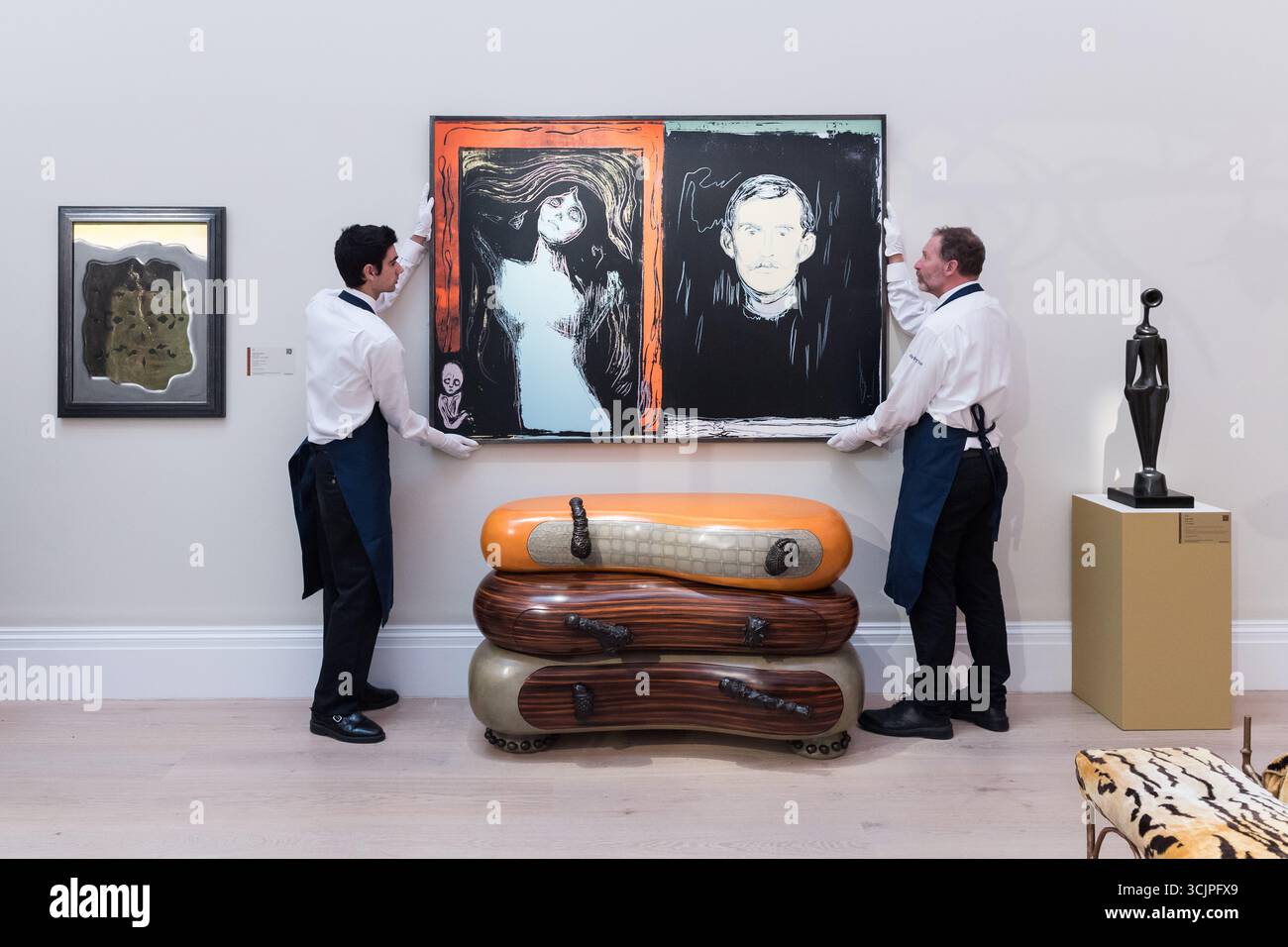 LONDRES, ROYAUME-UNI - 08 SEPTEMBRE 2025 : les manutentionnaires d'art tiennent "Madone et Self-Portrait avec le bras de squelette (après Munch)" par Andy Warhol, estimation : £1 500 000 - 2 000 000 lors d'un appel photo à la maison de vente aux enchères Sotheby's pour l'exposition 'Pauline Karpidas : The London Collection' et les ventes à Londres, Royaume-Uni le 08 septembre 2025. L'extraordinaire collection personnelle de la légendaire mécène et esthète Pauline Karpidas, présentant les chefs-d'œuvre de l'art surréaliste et du design de meubles qui ornaient sa maison unique à Londres, sera offerte chez Sotheby's les 17 et 18 septembre, toget Banque D'Images