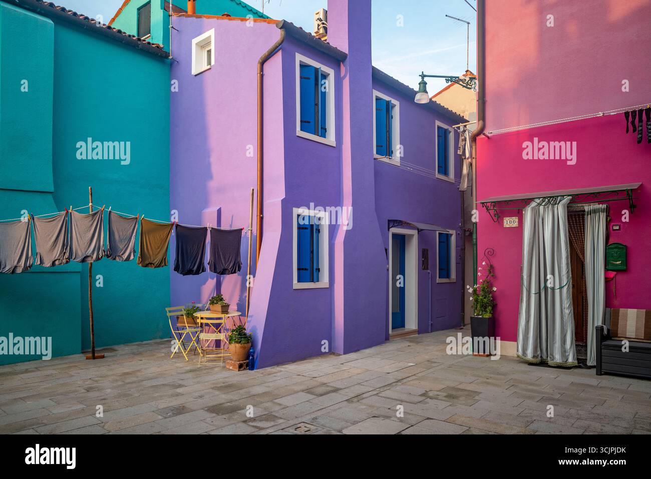 Maisons colorées de l'île de Burano brillantes dans la lumière chaude du coucher du soleil d'automne, près de Venise, Italie. Banque D'Images