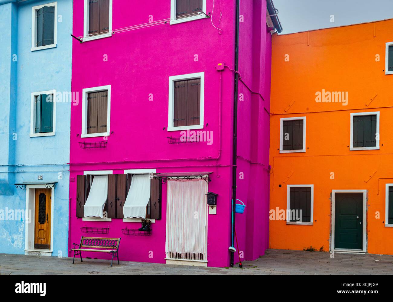 Maisons colorées de l'île de Burano brillantes dans la lumière chaude du coucher du soleil d'automne, près de Venise, Italie. Banque D'Images