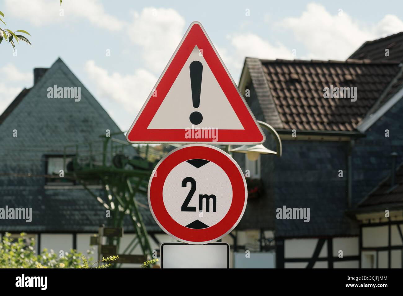 Avertissement exclamation hauteur limite 2m panneau routier Village. Gros plan des panneaux de signalisation indiquant la prudence et une limitation de hauteur du véhicule de deux mètres, locat Banque D'Images