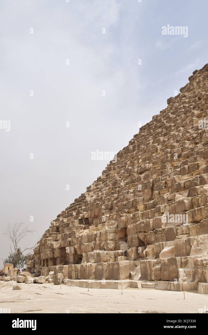 Gros plan de la Grande Pyramide de Gizeh, Égypte, montrant des blocs de pierre massifs de l'architecture ancienne sous ciel clair, merveille historique du monde. Banque D'Images