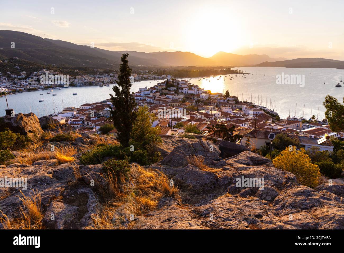 Vue de maisons, baie et port de plaisance au coucher du soleil dans la ville de Poros, île de Poros, îles Saroniques, Grèce Banque D'Images