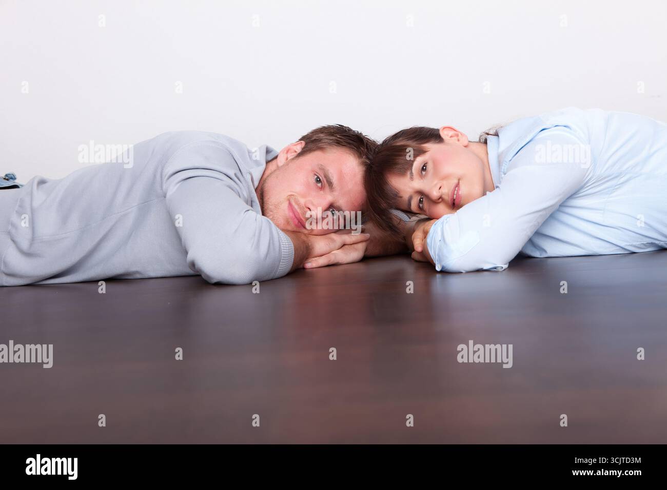 couple couché sur le plancher en bois Banque D'Images