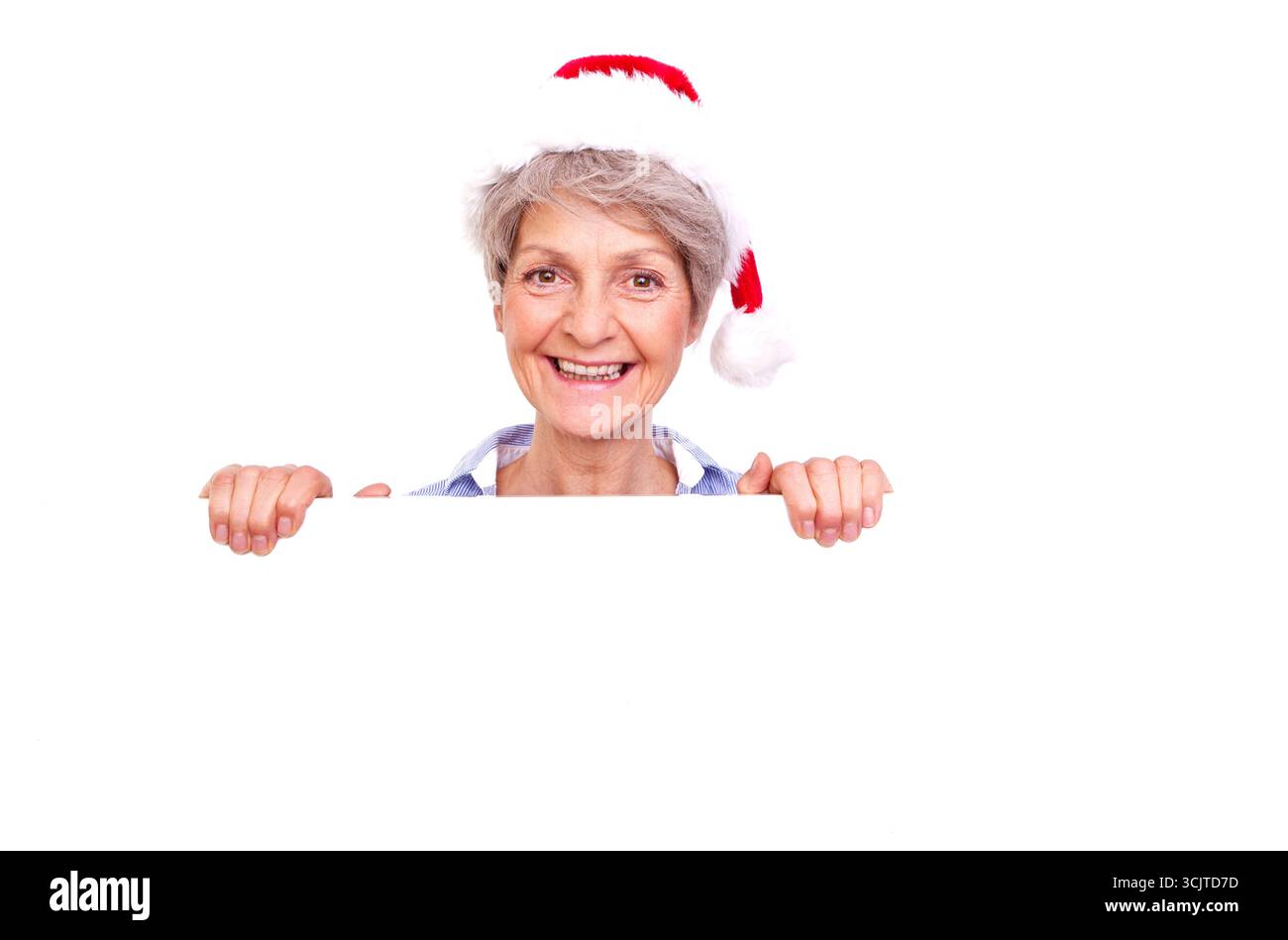 Senior féminin avec chapeau de Père Noël tenant sur une affiche blanche vierge, vue de face Banque D'Images