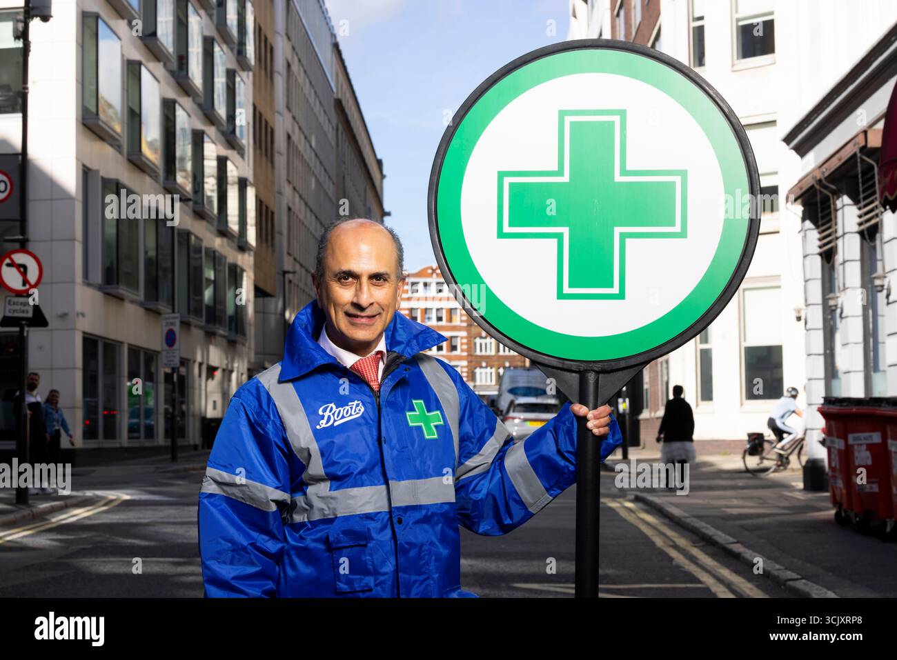 SOUS EMBARGO JUSQU'À 0001 MERCREDI 10 SEPTEMBRE ÉDITORIAL USAGE ONLY Sanjay Nathwani, un pharmacien Boots habillé comme un « pharmacien de sucette » pour aider les enfants à traverser la route pendant la course scolaire tout en rappelant aux parents de se rendre d'abord dans leur pharmacie pour obtenir des conseils de santé alors que la recherche révèle que près d'un tiers des adultes britanniques tombent malades après l'été. Date de la photo : mardi 9 septembre 2025. Banque D'Images