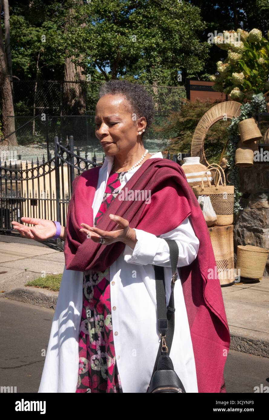 Au festival Wakanda de 2025, une femme distinguée tient ses mains uut dans la prière silencieuse. À Mount Vernon, Westchester, New York. Banque D'Images